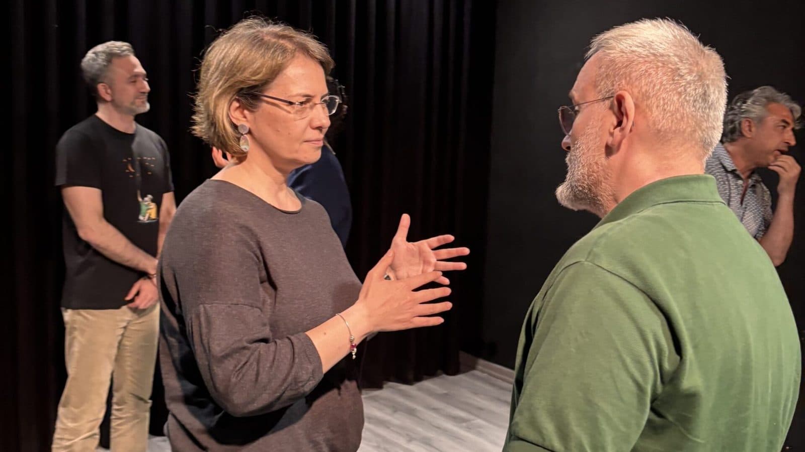Yetişkin katılımcılar sahnede eğitmenle karşılıklı çalışıyor